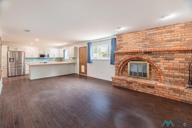 Unfurnished living room featuring a fireplace, dark wood-style flooring, and recessed lighting