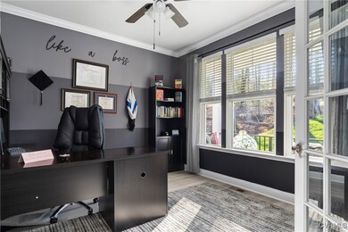 Home office with crown molding, ceiling fan, and l