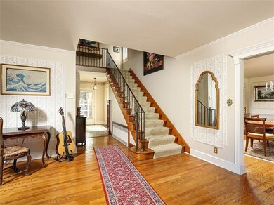 Large entry with oak floors and open staircase to 