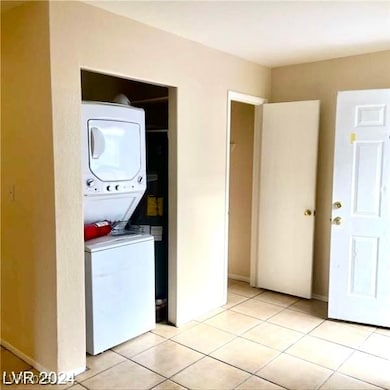 Laundry room featuring stacked washing machine and