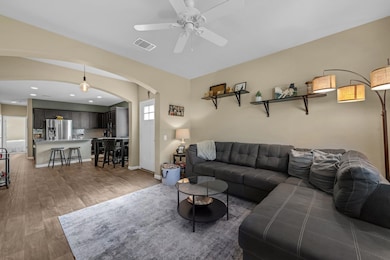 Living area with arched walkways, a ceiling fan, 