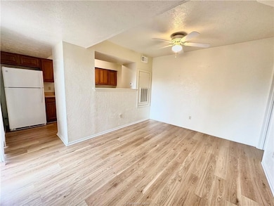 Unfurnished living room with ceiling fan, light ha