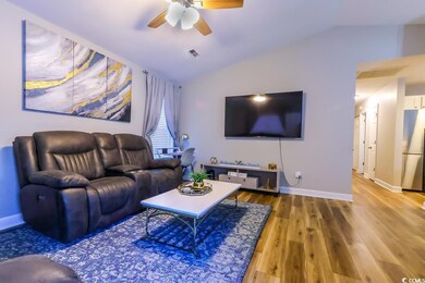 Living room with wood-type flooring, lofted ceilin