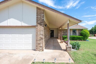 Entrance to property with a garage and a lawn