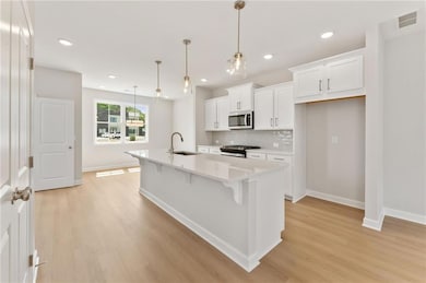 White cabinets with gleaming white tile backsplash.