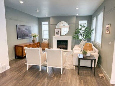 Living room featuring a glass covered fireplace, dark wood-style flooring, and recessed lighting