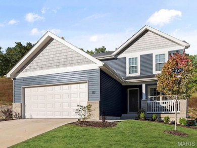 View of front of home featuring a porch, a front yard, and a garage