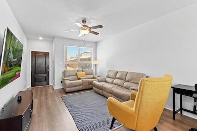Living room with baseboards, ceiling fan, and lig