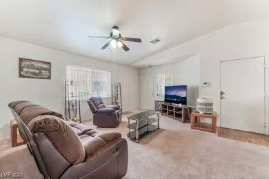 Carpeted living area with a ceiling fan