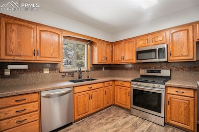 Large Kitchen with Oak Cabinets and Solid Surface Counters with Views to the Large Backyard!