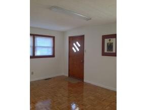 Den with refinished wood floor