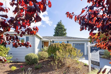 Ranch-style home featuring an attached garage and concrete driveway