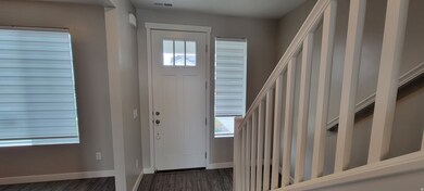 Entryway featuring baseboards and dark wood-style floors