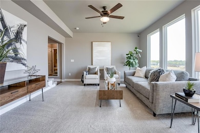 Carpeted living room with ceiling fan