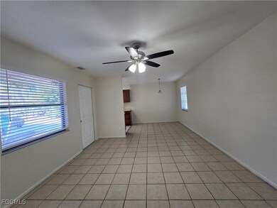 Unfurnished living room featuring a ceiling fan, light tile patterned flooring, and plenty of natural light