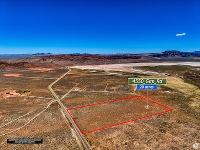Aerial view of sparsely populated area featuring a mountainous background and property parcel outlined