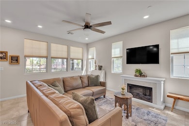 Living area with a ceiling fan, recessed lighting,