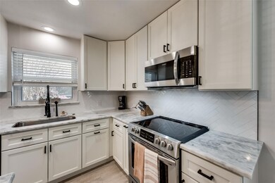 Kitchen with light stone counters, stainless steel
