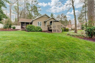 Back of house featuring a wooden deck and a lawn