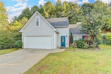 Traditional-style house featuring a garage, concrete driveway, a front yard, roof with shingles, and a chimney