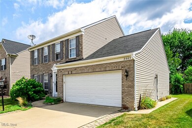 View of front facade featuring brick siding, concrete driveway, roof with shingles, and a garage