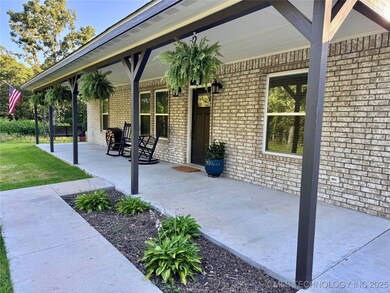 Charming covered front porch with fresh landscapin
