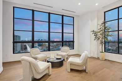 Wrapped in natural light, this intimate corner of the gathering room is framed by stunning floor-to-ceiling windows on two sides.. A perfect spot for morning coffee or evening conversation, this sophisticated sitting area invites you to relax while taking in the wraparound views.
