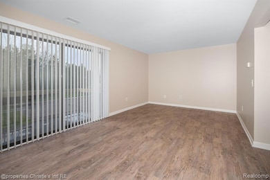 Unfurnished room with wood finished floors and baseboards