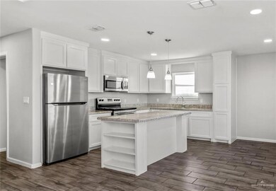 Kitchen featuring appliances with stainless steel finishes, open shelves, white cabinets, and recessed lighting