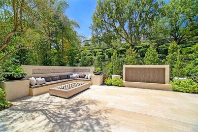 Elegant stone patio features stone seating wall wi