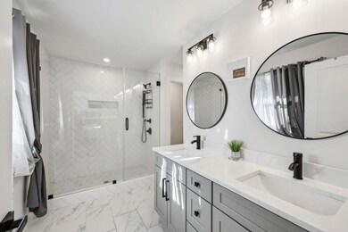 Primary Suite with an Ensuite Bath featuring a Walk-In Shower with Chevron Tile