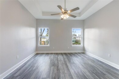 Master bedroom with vinyl flooring and tray ceilin