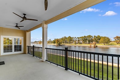 Balcony featuring a water view and a ceiling fan