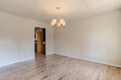 Dining Room has Wood Laminate Floors & Chandelier.