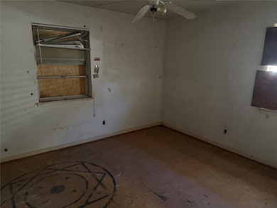 Empty room with a ceiling fan and tile patterned floors