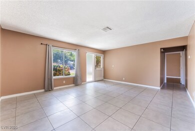 Unfurnished room with a textured ceiling, light ti