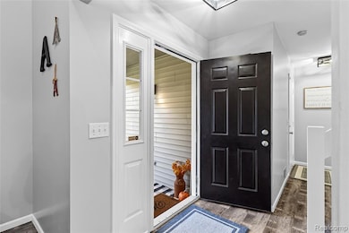 Foyer entrance featuring dark wood-style floors and baseboards
