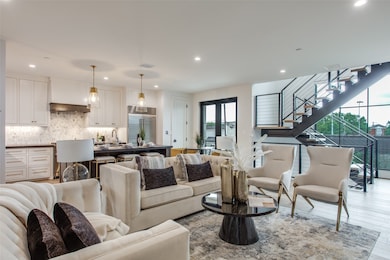 Living room with light wood-style flooring, recessed lighting, and stairs