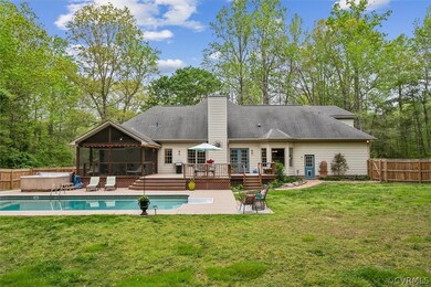 Rear view of property featuring a swimming pool side deck, a yard, and a sunroom