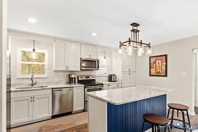Kitchen with tasteful backsplash, appliances with stainless steel finishes, a breakfast bar, light wood-type flooring, and recessed lighting
