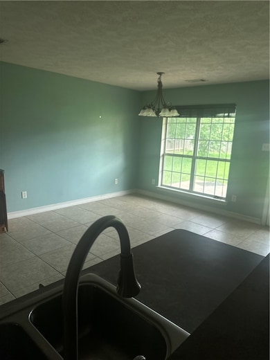 Unfurnished dining area with a chandelier, a textu