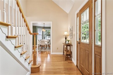 Entryway with light wood-type flooring and vaulted