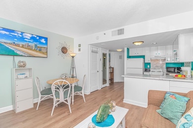 Living room with a textured ceiling, baseboards, l