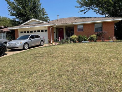 Ranch-style house with a garage and a front lawn