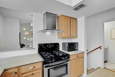 Kitchen featuring black microwave, visible vents,