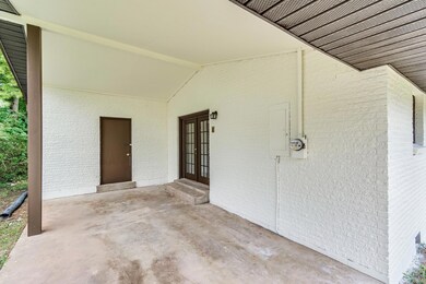 Carport area features an entrance to the kitchen as well as an outdoor storage area