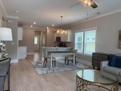 Living area featuring baseboards, light wood-style flooring, ceiling fan, ornamental molding, and recessed lighting