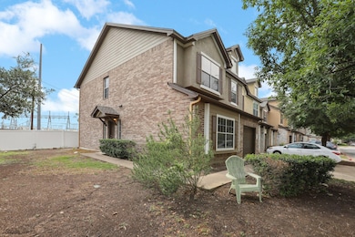 View of home's exterior featuring fence and brick