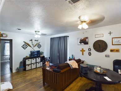 Living room featuring a ceiling fan, a textured ce