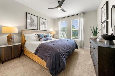 Bedroom featuring light carpet, ceiling fan, and b